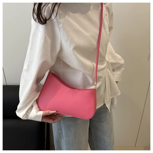 Detail of pink hobo bag with gold buckle on model with white shirt and jeans