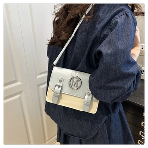 Détail du sac bandoulière bleu clair et crème avec boucle en métal M et doubles lanières