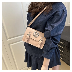 Détail du sac à bandoulière beige avec logo M en métal et sangles en cuir réglables
