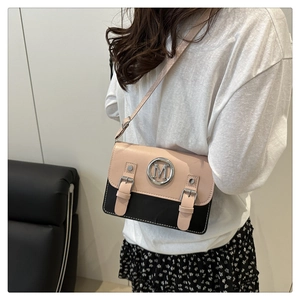 Vue détaillée du sac bandoulière bicolore en cuir avec logo M porté par mannequin