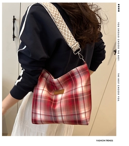 Detail of red checkered canvas tote bag with wave pattern wide shoulder strap on model