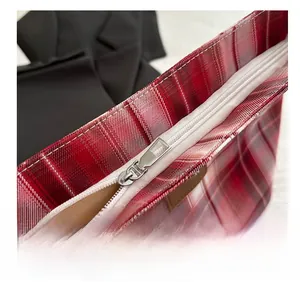 Detail view of the silver metal zipper and red checkered canvas on a tote bag