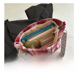 Internal view of the red plaid tote bag showing its large capacity and zipper closure
