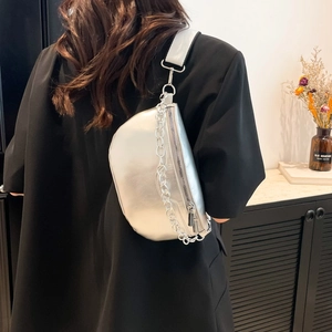 Silver metallic saddle bag with chunky chain and white strap worn by a model