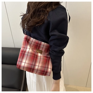 Detail of red and white checkered shoulder bag with fashion leather patch and chain strap