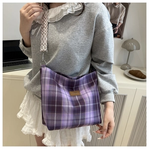 Close-up of purple plaid tote bag with decorative wide geometric pattern shoulder strap