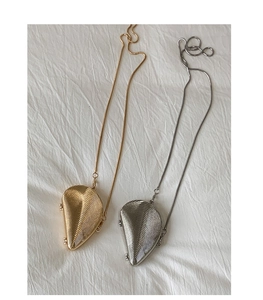 Detailed view of gold and silver shell-shaped evening bags with metallic ribbing and chains