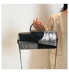 Dettaglio elegante borsa da sera nera e pitonata con manico metallico e tracolla sottile