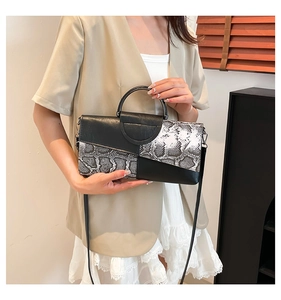 Dettaglio della borsa a tracolla trendy con patchwork in pelle nera e motivo serpente