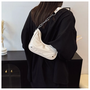 Schicke cremeweiße Halbmond-Schultertasche mit Silberkette an einem Model präsentiert