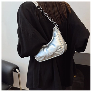 Detailansicht der silbernen Hobo-Tasche mit klobiger Metallkette und Logo-Schrift