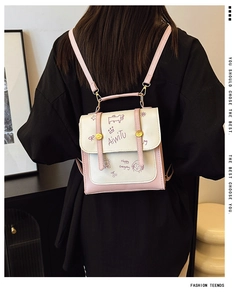 Detail eines rosa-weißen Rucksacks mit süßen Schweinchen-Grafiken und verstellbaren Riemen