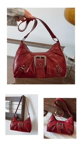 Detail view of red glossy leather shoulder bag featuring a large decorative metal buckle