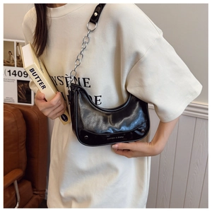 Detail of black glossy leather hobo bag with silver chain strap and fashion text logo