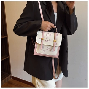 Rosa und beigefarbener Rucksack aus Kunstleder mit Cartoon-Graffiti und Druckknopf-Detail