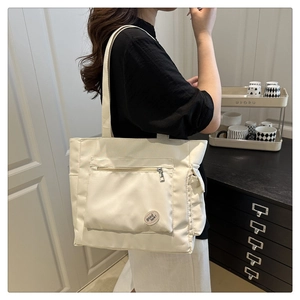 Detail of canvas tote bag with front zipper pocket and good luck embroidery patch