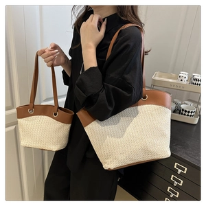 Detail showing woven straw tote bag set with brown leather handles and matching small pouch
