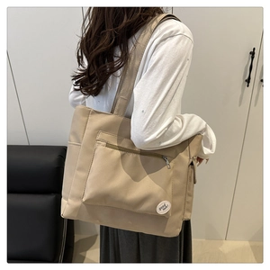 Detail of minimalist canvas tote bag with outer zipper pocket and side storage pocket