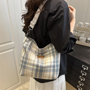 Blue and yellow plaid canvas tote bag with wide geometric woven shoulder strap