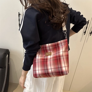 Red and white checkered crossbody bag with wide geometric strap and leather logo tag