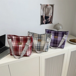 Three plaid tote bags in burgundy, off-white, and purple with wide geometric straps