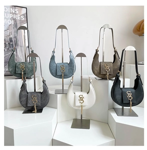 Detalle de bolsos hobo de media luna en seis colores con logos de flecos dorados