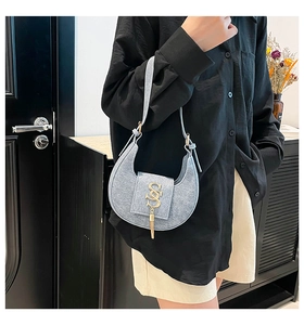 Detalle de bolso medialuna azul claro con herraje SS dorado y borla metálica