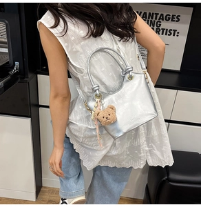 Borsa a secchiello metallizzata argento con ciondolo a orso e foulard in seta