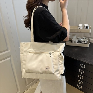 Sac fourre-tout minimaliste en toile blanche avec poche zippée et écusson rond