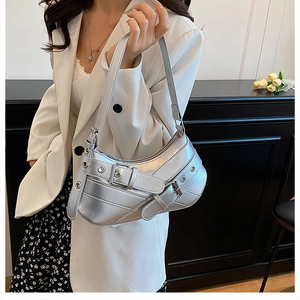 Close-up of metallic silver shoulder bag with belt buckle and metal eyelet details