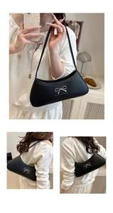Close-up of black PU leather underarm bag with silver bow accent on the shoulder strap