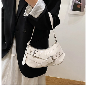Détail d'un sac baguette blanc en demi-lune avec sangle à œillets et boucle métallique