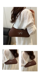 Detail of dark brown faux leather baguette bag with a silver bow clasp and shoulder strap