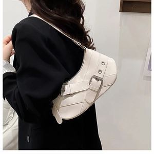 Detail of creamy white patent leather underarm bag with silver buckles and hardware