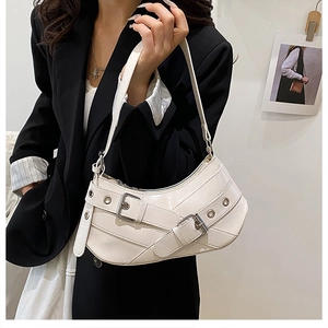 Détail du sac baguette demi-lune en cuir PU blanc avec œillets et boucles argentés