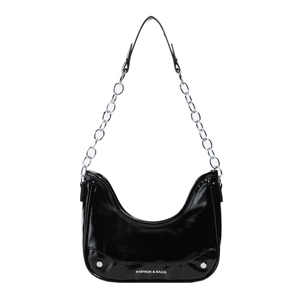 Fashionable black crescent shoulder bag with silver studs and chain strap on white background