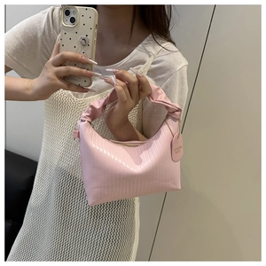 Detail of pink vertical striped texture and chic ruched handle on a fashion handbag