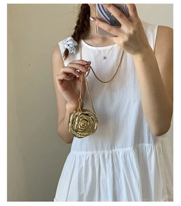 Golden 3D rose flower mini bag with chain shown being held in a mirror selfie for scale