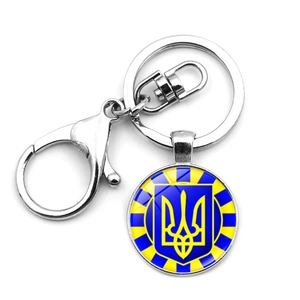Detailed macro view of Ukraine Tryzub trident symbol in round glass cabochon keychain