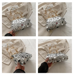 Detail of silver sequin evening bag featuring gold kiss-lock clasp and metal top handle