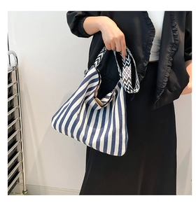 Detail of blue and white striped canvas tote bag with geometric printed wide shoulder strap