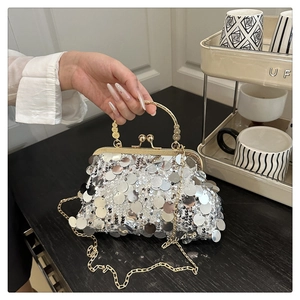 Détail du sac de soirée à paillettes argentées avec poignée dorée et fermoir gravé