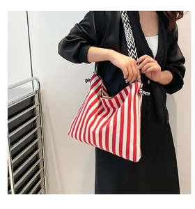 Detail of red striped canvas tote bag with geometric pattern woven shoulder strap