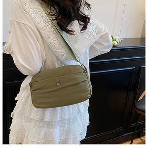Olive green nylon crossbody bag featuring a round metallic M logo and adjustable strap