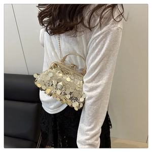 Détail de la pochette de soirée à paillettes avec chaîne dorée portée par un mannequin