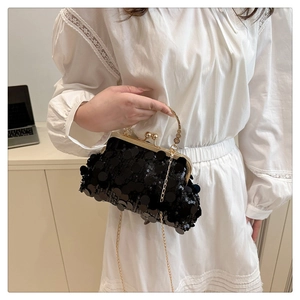 Détail de la pochette de soirée noire à paillettes avec anneau doré et chaîne métal