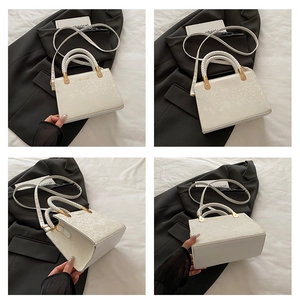 Detail views of white snakeskin texture handbag with gold hardware and woven handles