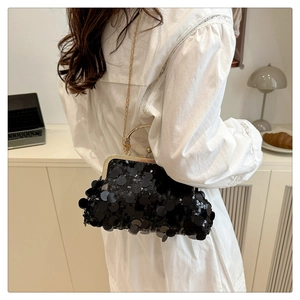 Dettaglio elegante borsa da sera con paillettes nere, catena dorata e manico in metallo