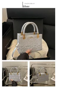 Detailed view of silver snakeskin texture bag with golden buckle and woven handle