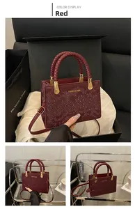 Detail of red snake-patterned handbag with woven handles and gold-tone metal hardware